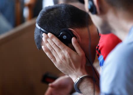 A defendant reacts, during the trial in which four men are charged with causing the death of 71 migrants who suffocated in a lorry found beside an Austrian motorway in 2015, in Kecskemet, Hungary June 21, 2017. REUTERS/Bernadett Szabo