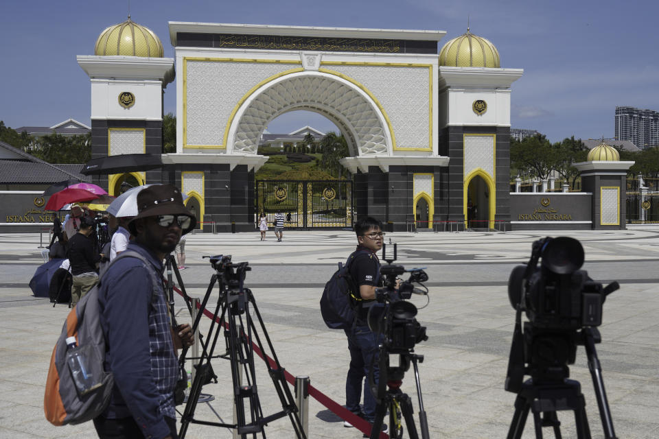 Journalists gather outside National Palace in Kuala Lumpur, Malaysia, Thursday, Feb. 27, 2020. Malaysia's king summoned Mahathir Mohamad to the palace Thursday, fueling talks that he may have majority support to return as the next prime minister after his abrupt resignation and the collapse of his ruling coalition this week. (AP Photo/Vincent Thian)