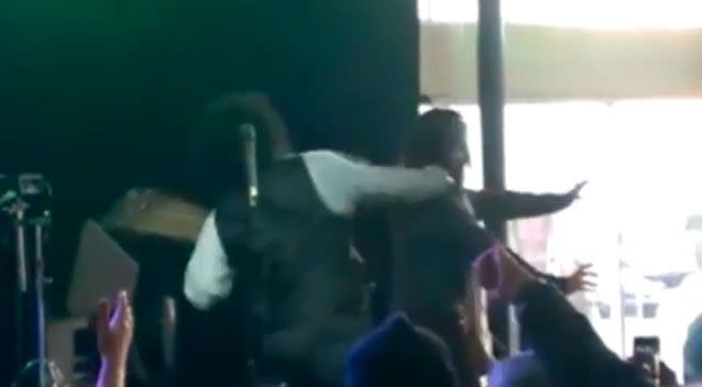 Without warning, Afroman turns around and delivers a powerful blow to the stage intruder's face. Facebook