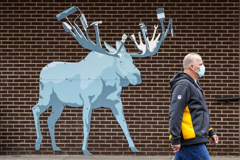A customer leaves the Maine Hardware store where an artistic rendition of a moose, the state animal, decorates an outside wall, Friday, May 15, 2020, in Portland, Maine. Another 38 people tested positive for the new coronavirus but there were no deaths in the previous 24 hours, the Maine Center for Disease Control reported Friday. (AP Photo/Robert F. Bukaty)