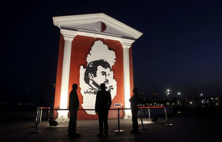 FILE PHOTO: People look at an artwork depicting QatarÕs Emir Sheikh Tamim Bin Hamad Al-Thani during the Winter Festival at Katara Cultural Village in Doha, Qatar, January 18, 2018. REUTERS/Naseem Zeitoon//File Photo