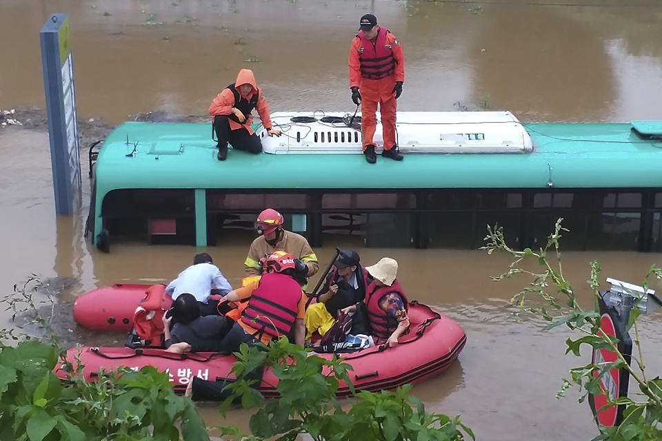 Rescue workers evacuate passengers on a boat from a submerged bus due to heavy rain in Paju, South Korea, Thursday, Aug. 6, 2020. Korean Meteorological Administration issued a warning of heavy rain for Seoul and central area. (Paju Fire Station via AP).