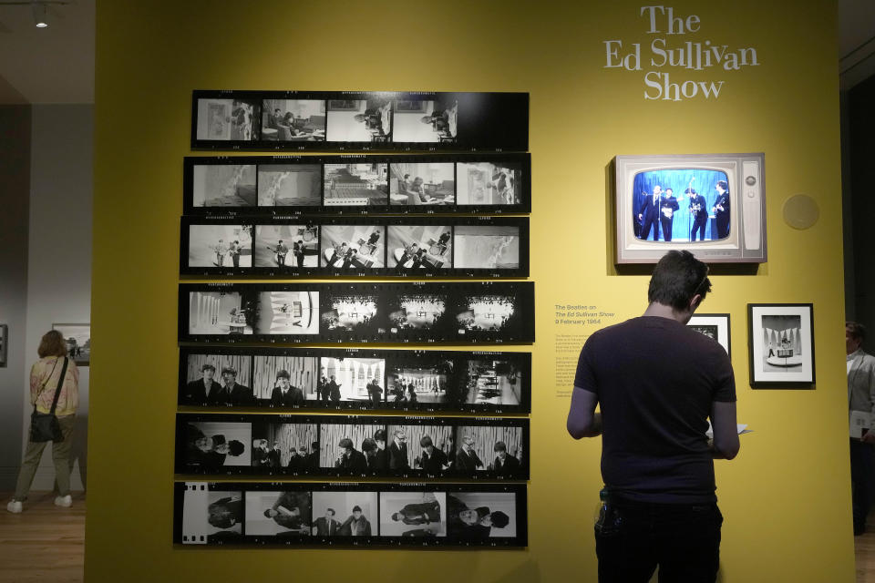 A visitor looks at pictures during a preview of Paul McCartney Photographs 1963-64: Eyes of the Storm exhibition at the National Portrait Gallery in London, Britain, Tuesday, June 27, 2023. The exhibition consists of unseen photographs taken by Paul McCartney from the Beatles at the height of Beatlemania. The gallery will open it's doors from June 28, 2023 until October 1, 2023. (AP Photo/Frank Augstein)