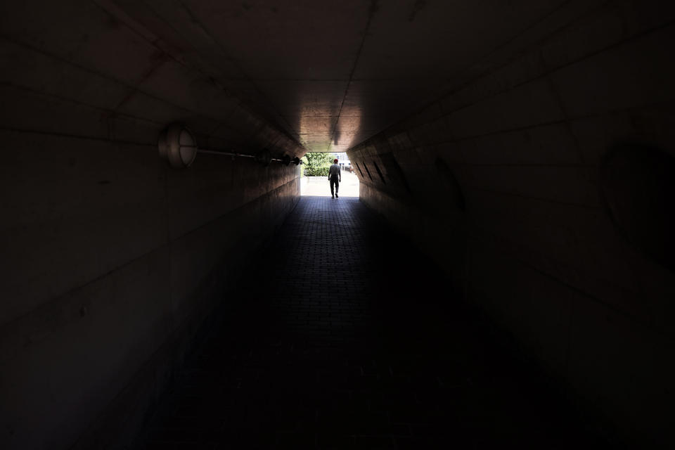 Hidekazu Tamura, 99, takes a walk though a long tunnel as a daily routine in Tokyo Friday, Aug. 28, 2020. Amid commemorations for Wednesday's 75th anniversary of the formal Sept. 2 surrender ceremony that ended WWII, Tamura, a former Japanese American living in California, has vivid memories of his time locked up with thousands of other Japanese-Americans in U.S. intern camps. Torn between two warring nationalities, the experience led him to refuse a loyalty pledge to the United States, renounce his American citizenship and return to Japan.(AP Photo/Eugene Hoshiko)