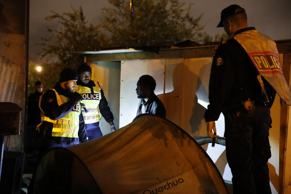 Police officers evacuate a migrant as police forces clear an area Thursday, Nov. 7, 2019 in the north of Paris. Migrant encampments are becoming increasingly visible in the French capital. Police cleared Thursday several thousand people from a northern Paris neighborhood where migrants have repeatedly been removed. They are taken to shelters, and some eventually sent home. (AP Photo/Francois Mori)