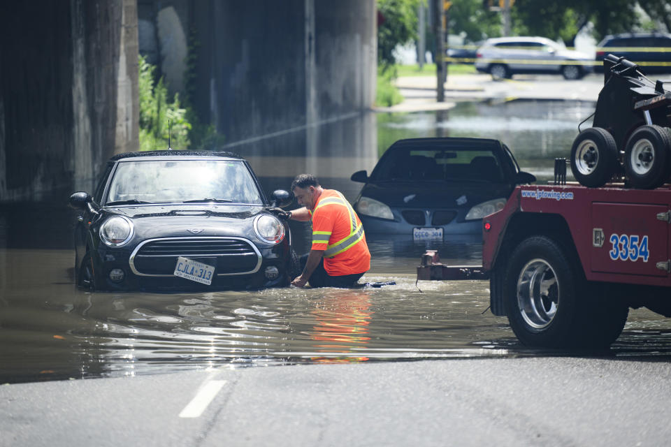 A tow truck operator responds to submerged vehicles at an underpass at Parkside Drive and Lake Shore Blvd., after heavy rain caused flooding, in Toronto on Tuesday, July 16, 2024. THE CANADIAN PRESS/Christopher Katsarov