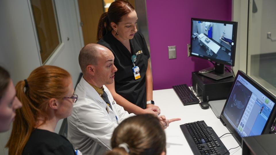 Scientists sitting around a computer screen