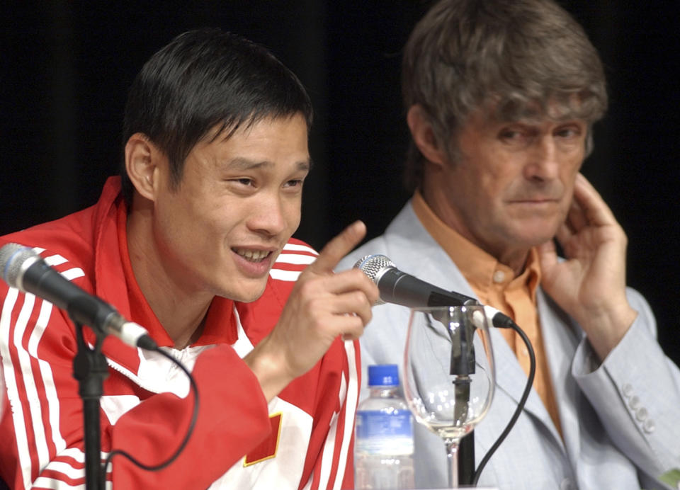 FILE - China's national soccer team member Fan Zhiyi, left, speaks during during a press conference as he is flanked by China's national soccer coach Bora Milutinovic, in Macau, China, Friday, May 24, 2002, before the Chinese final warm up match against Portugal on Saturday before the World Cup tournament. China is missing out on the World Cup again despite spending millions — probably billions — to develop the game, a reported priority of Xi Jinping, the all-powerful general secretary of the Chinese Communist Party. (AP Photo/Vincent Yu, File)