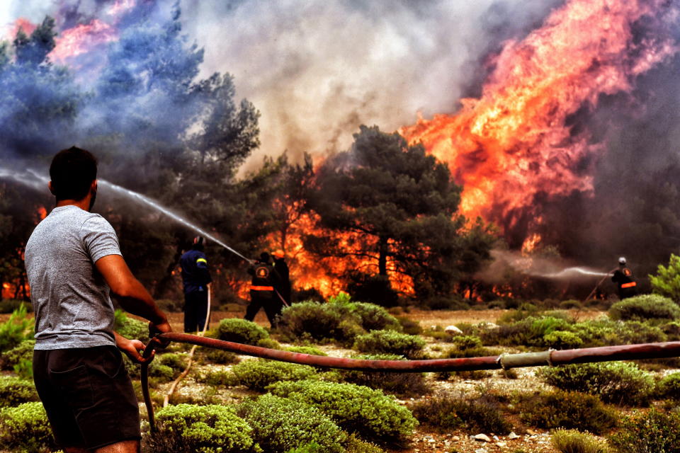 Firefighters and volunteers try to extinguish a bushfire raging in Verori in southern Greece on July 24. Source: AAP