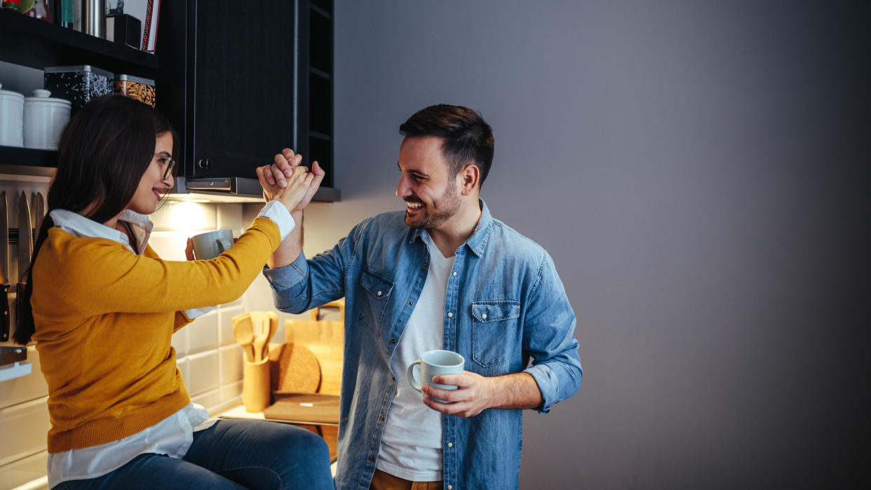 Cropped shot of an affectionate young couple in the kitchen, giving a high five.