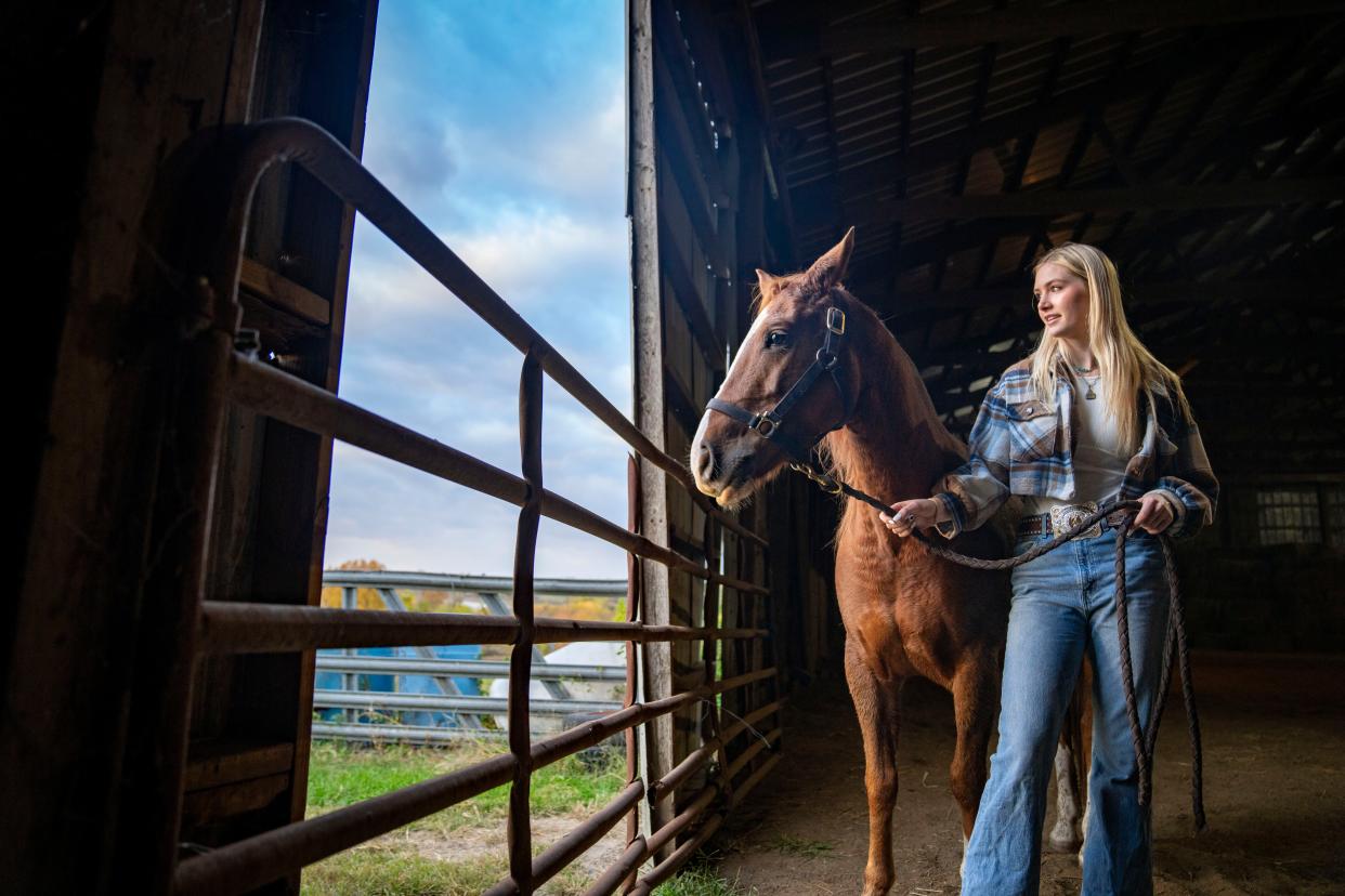 Elivia Papcun holds Wall-E, one of her horses, at her home in Norwalk.