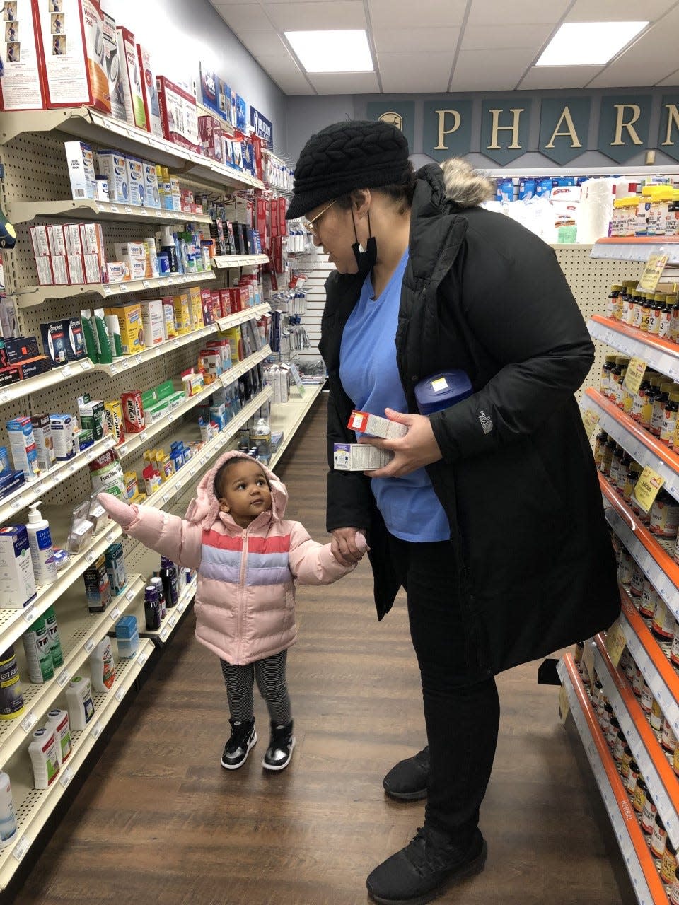 Adelaide Maysonet of Morrisville and her granddaughter, Harmony Johnson, 2, shop for  children's over-the-counter painkiller and cough medicine at Burns Pharmacy in Morrisville Monday.  Maysonet said she wanted to have some medicines at home if Harmony needed them over the holidays.