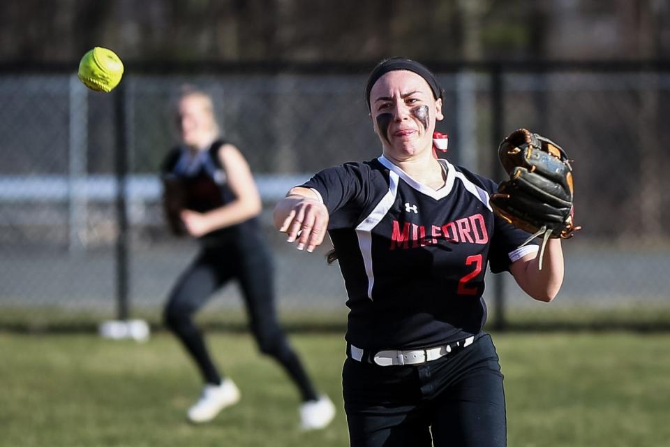 Milford's Emily Piergustavo picks off the runner first base during the Scarlet Hawks' win over Stoughton in April 2017. Piergustavo was just named an assistant softball coach at Tufts.