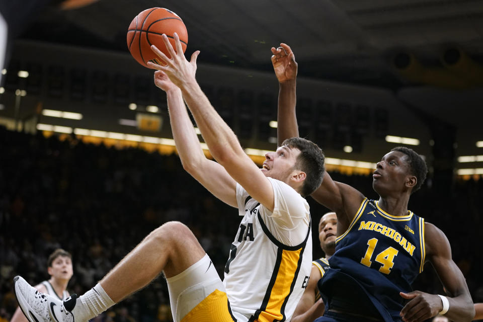 Iowa forward Filip Rebraca, left, fights for a rebound with Michigan forward Moussa Diabate (14) during the second half of an NCAA college basketball game, Thursday, Feb. 17, 2022, in Iowa City, Iowa. Michigan won 84-79. (AP Photo/Charlie Neibergall)