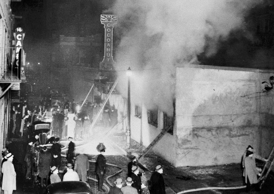FILE - In this Nov. 28, 1942 file photo, smoke pours from the Cocoanut Grove nightclub during a fire in the Back Bay section of Boston. A 2019 documentary film, "Six Locked Doors: The Legacy of Cocoanut Grove," tells the story of the disaster that claimed the lives of 492 people, leading to an overhaul and stricter enforcement of building safety codes. (AP Photo, File)
