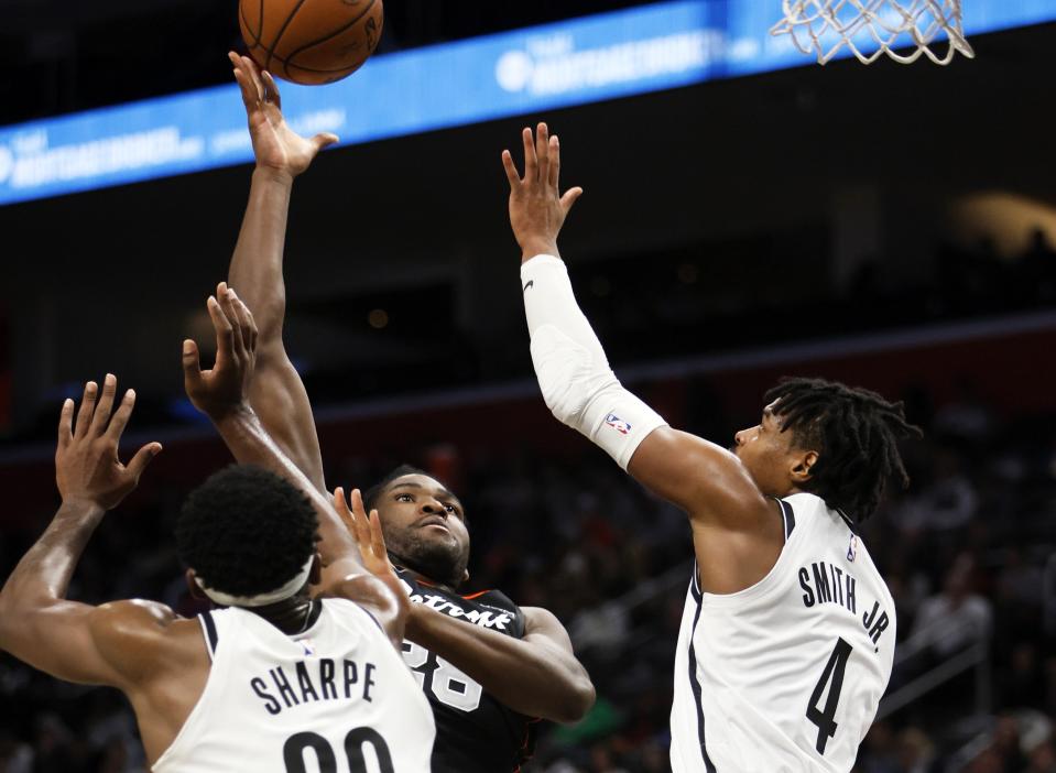 Detroit Pistons center Isaiah Stewart (28) shoots against Brooklyn Nets center Day'Ron Sharpe (20) and guard Dennis Smith Jr. (4) during the first half of an NBA basketball game Tuesday, Dec. 26, 2023, in Detroit. (AP Photo/Duane Burleson)