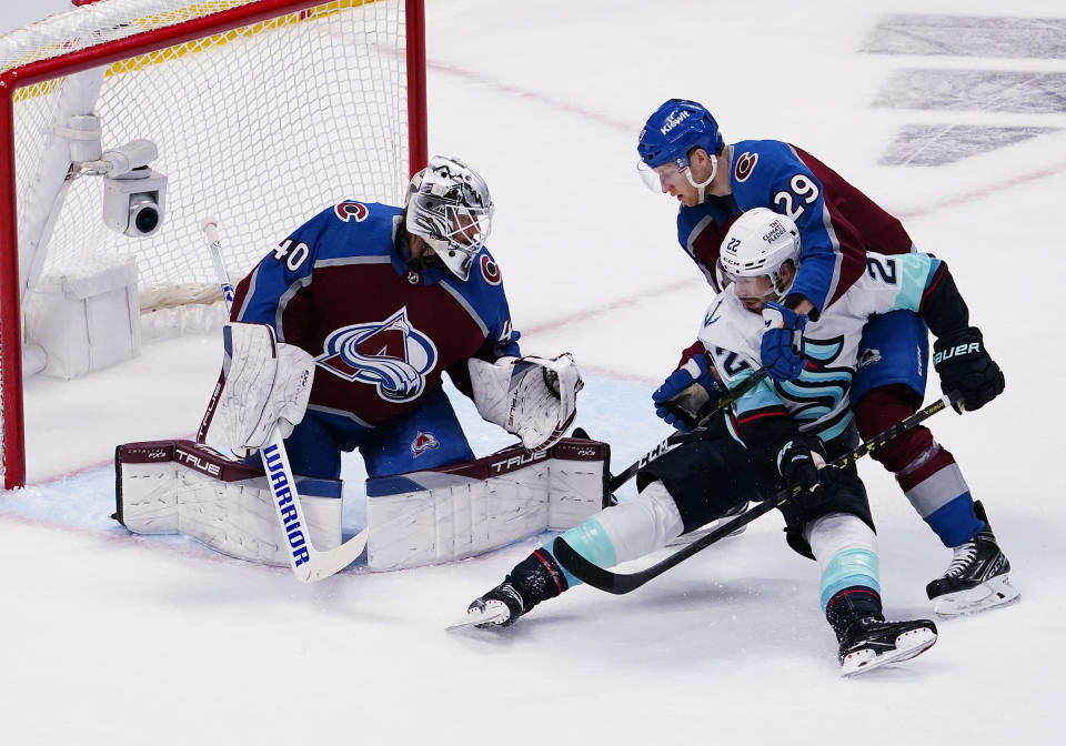 Colorado Avalanche center Nathan McKinnon (29) tangles with Seattle Kraken right wing Oliver Bjorkstrand (22) in front of Avalanche goaltender Alexandar George (40) during the first period in Game 1 of a first-round NHL hockey playoff series Tuesday, April 18, 2023, in Denver (AP Photo/Jack Dempsey)