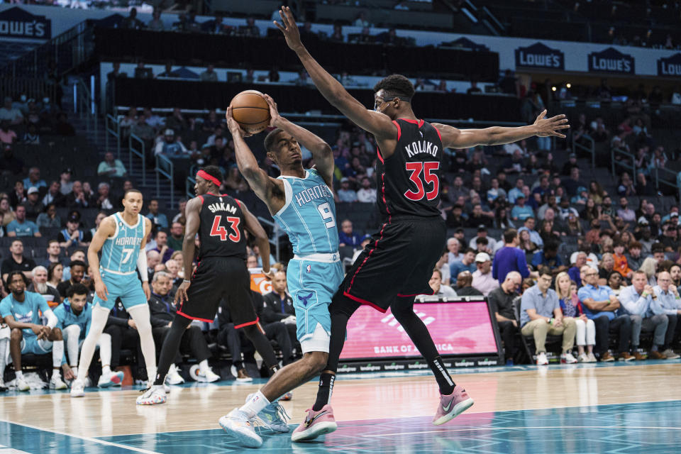 Toronto Raptors center Christian Koloko (35) guards Charlotte Hornets guard Theo Maledon (9) during the first half of an NBA basketball game in Charlotte, N.C., Tuesday, April 4, 2023. (AP Photo/Jacob Kupferman)