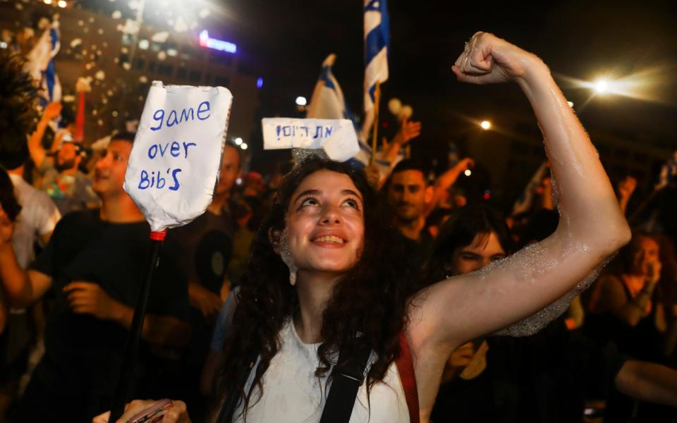 Israelis celebrate the swearing in of a new government on June 13. The sign reads: "Game over Bibi" - a reference to a popular nickname for Mr Netanyahu - Oded Balilty /AP