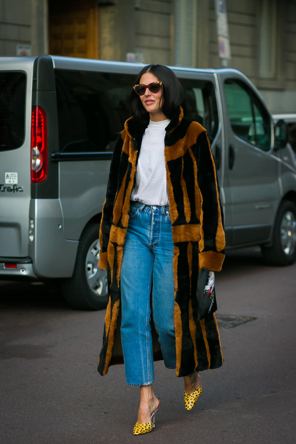 Gilda Ambrosio wears the unofficial outfit of Milan Fashion Week: a faux-fur duster, vintage denim, and ladylike heels.