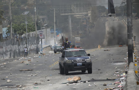 A Haitian National Police car drives next to barricades on a street in Port-au-Prince, Haiti, July 8, 2018. REUTERS/Andres Martinez Casares