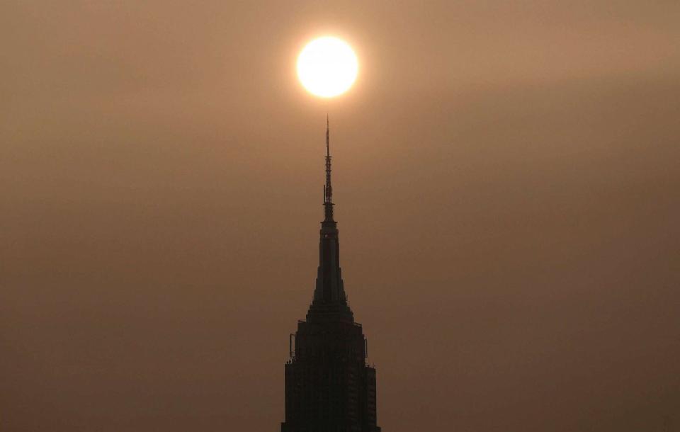 PHOTO: Wildfire smoke drifting back into the Northeast shrouds the sun as it rises behind the Empire State Building in New York City. Oct. 1, 2023, as seen from Hoboken, NJ. (Gary Hershorn/ABC News)