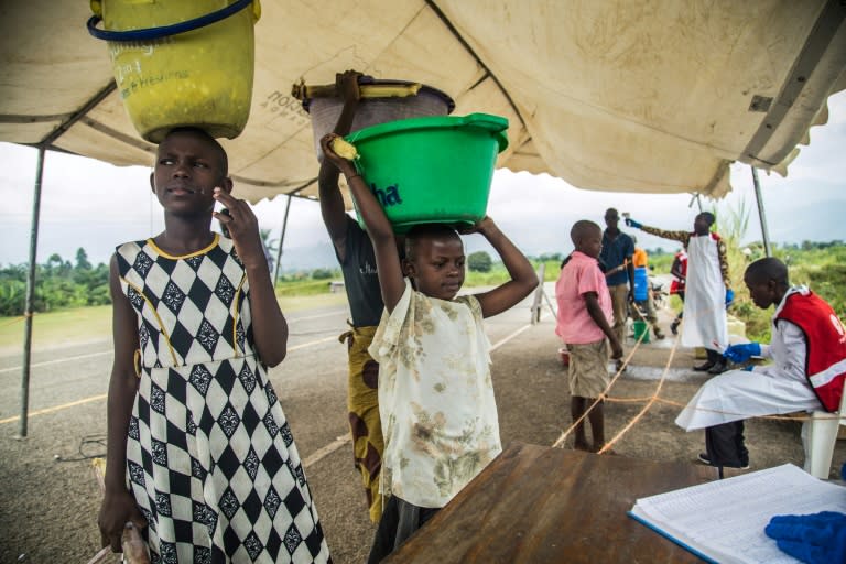 Medical staff check people from the Democratic Republic of Congo, crossing into Uganda at a screening facility in Bundibugyo district, western Uganda -- but the Red Cross says its efforts to contain the disease can meet with distrust