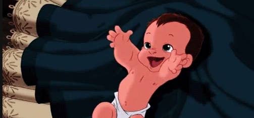 Animated baby Kuzco from "The Emperor's New Groove", lying on a dark blanket, smiling and raising both hands in excitement