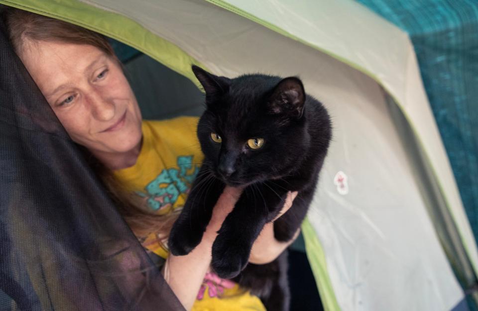 Shannon Augustino, 35, holds up one of her cats that lives with her at the Toms River homeless camp.