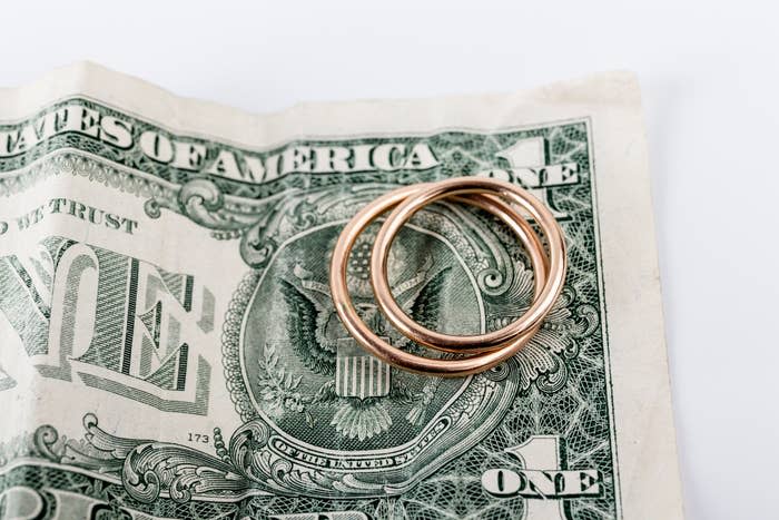 A U.S. one-dollar bill with three gold rings placed on top