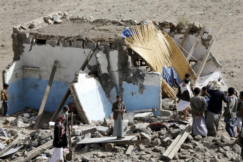 La gente se reúne en los escombros de una casa en ruinas en el pueblo de Bait Regal.