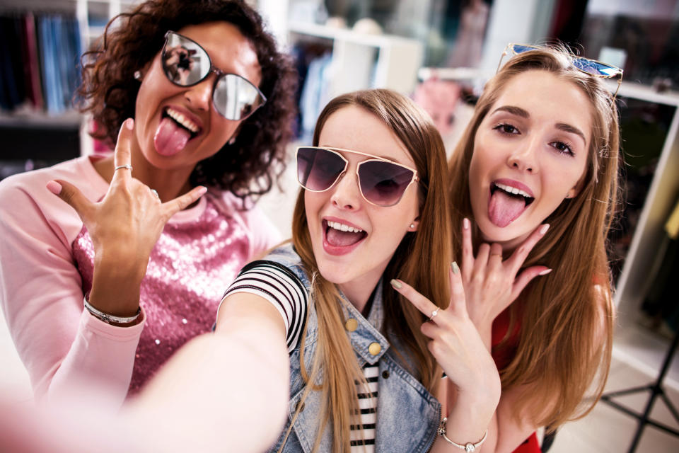 Three young girls taking a selfie while they shop.