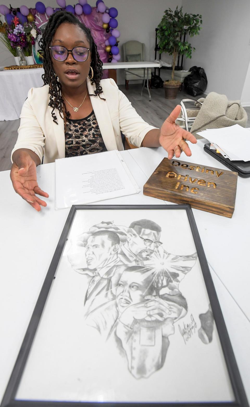 Crystal Aryitey, an educator who runs the nonprofit Destiny Driven, Inc., shows artwork and poetry written by her students in Montgomery, Ala., on Wednesday December 6, 2023.