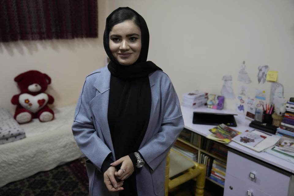 An Afghan university student Bahija Aman, 21, 3rd year anthropology major, smiles during an interview with The Associated Press at her home, in Kabul, Afghanistan, Thursday, Feb. 24, 2022. Kabul University, among Afghanistan’s oldest and most revered institutions of higher education, reopened Saturday six months after the Taliban retook the country. There were new restrictions in place, however, including gender segregation and mandatory Islamic dress. (AP Photo/Hussein Malla)