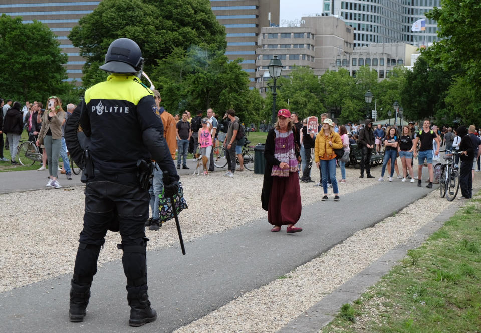 Protesters face the police, during a demonstration targeting the government’s handling of the coronavirus crisis, at Malieveld, the Hague, Netherlands, Sunday, June 21, 2020. Dutch police charged hundreds of what they called soccer fans with horses and a water cannon in the center of The Hague Sunday and warned people to stay away from the city center. (AP Photo/Michael Corder)