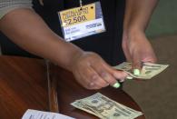 FILE- In this Aug. 9, 2018, photo a manager of a financial services store in Ballwin, Mo., counts cash being paid to a client as part of a loan. The nation's federal financial watchdog has announced its plans to roll back most of its consumer protections governing the payday lending industry. It's the Consumer Financial Protection Bureau's first rollback of regulations under its new Director, Kathy Kraninger, who took over the bureau late last year. California created what supporters called its own nation-leading, state-level version of the federal Consumer Financial Protection Bureau after critics said the Trump administration significantly weakened national protections Friday, Sept. 25, 2020. (AP Photo/Sid Hastings, File)