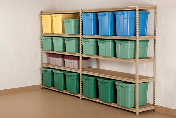 green-and-blue-and-yellow-plastic-storage-boxes-with-lids-on-a-metal-shelving-unit-in-a-basement