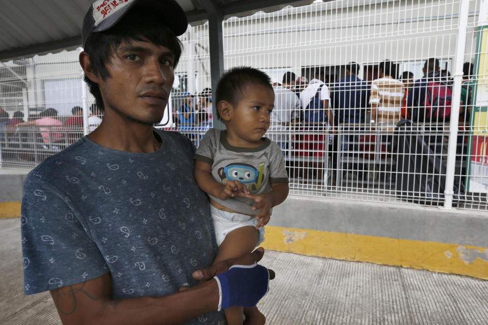 A man his son walk across the Suchiate river bridge as Central American migrants cross the border between Guatemala and Mexico, near Ciudad Hidalgo, Chiapas State, Mexico, Thursday, Jan. 17, 2019. Hundreds of Central American migrants are walking and hitchhiking through the region as part of a new caravan of migrants hoping to reach the United States. (AP Photo/Marco Ugarte)