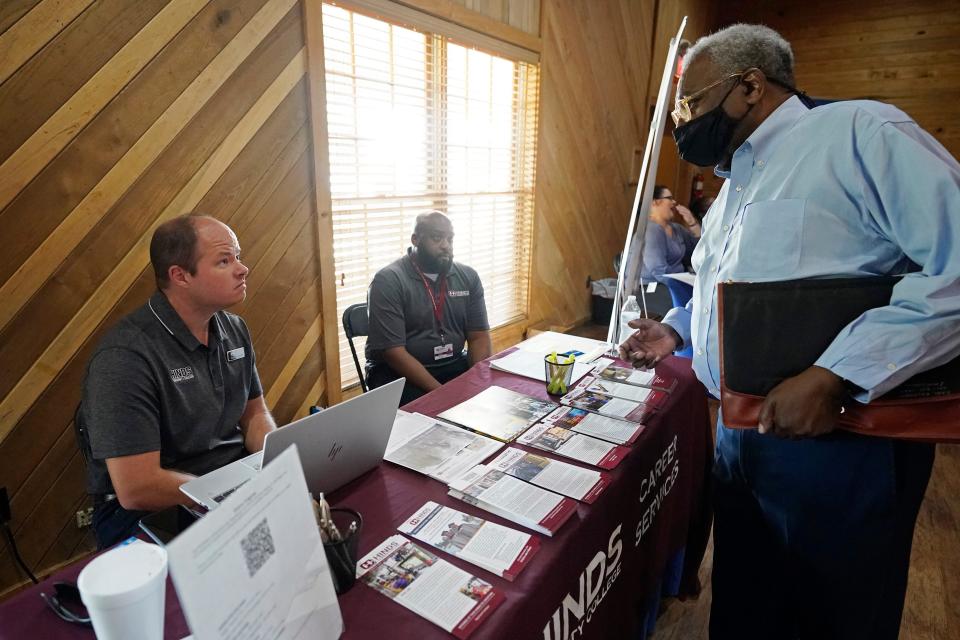 Robert Allen, director of work based learning, left, and Rod Mallett, work based learning coordinator, center, at Hinds Community College, discuss programs and opportunities with a job seeker, right, during the 2022 Mississippi Re-Entry Job Fair, in Jackson, Wednesday, June 22, 2022.