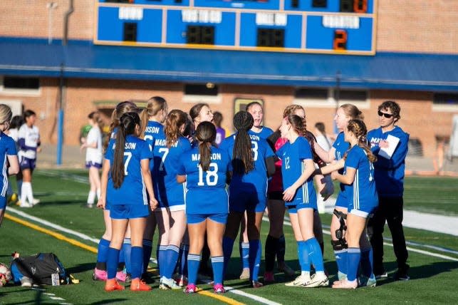 Coach Chris Sutherland huddles his team up in its March 11 season opener. The Lady Patriots are 7-0 as of April 5.