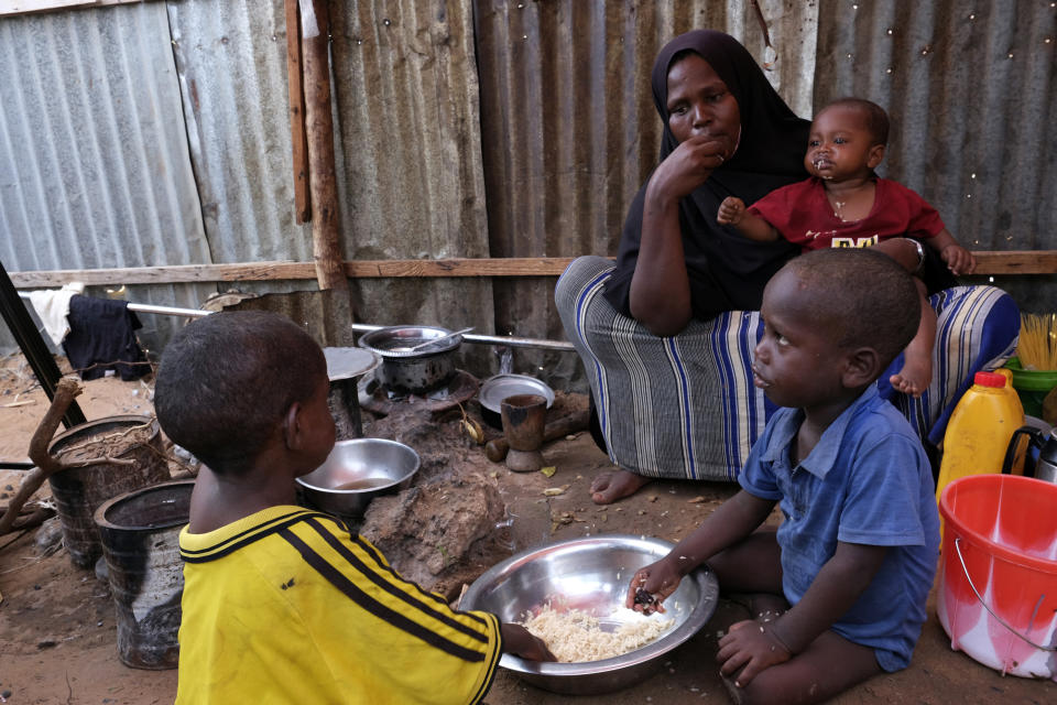 Hadiiq Abdulle Mohamed eats with her children as she speaks during an interview with Associated Press at an internally displaced people camp on the outskirts of Mogadishu, Somalia, Friday, March 24, 2023. This year’s holy month of Ramadan coincides with the longest drought on record in Somalia. As the sun sets and Muslims around the world gather to break their daily fasts with generous dinners, Hadiiq Abdulle Mohamed and her family have just water and whatever food might be at hand. (AP Photo/Farah Abdi Warsameh)