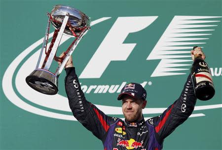 Red Bull Formula One driver Sebastian Vettel of Germany celebrates with his trophy on the podium after winning the Austin F1 Grand Prix at the Circuit of the Americas in Austin November 17, 2013. REUTERS/Mike Stone