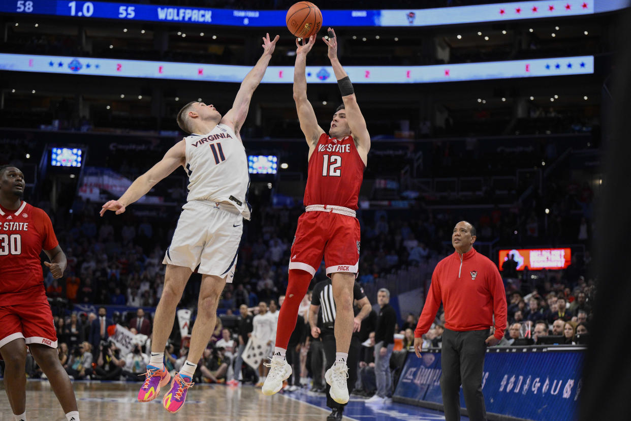 North Carolina State guard Michael O'Connell (12) shoots over Virginia guard Isaac McKneely (11) to tie the game 58-58 and sends the game into overtime at the end of the second half of an NCAA college basketball game in the semifinal round of the Atlantic Coast Conference tournament Friday, March 15, 2024, in Washington. (AP Photo/Nick Wass)