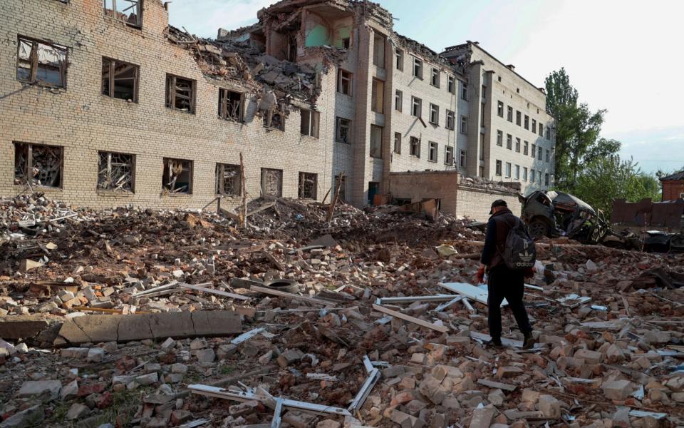 A local resident walks next to a building destroyed by a Russian military strike in the town of Bakhmut, Donetsk - SERHII NUZHNENKO /REUTERS