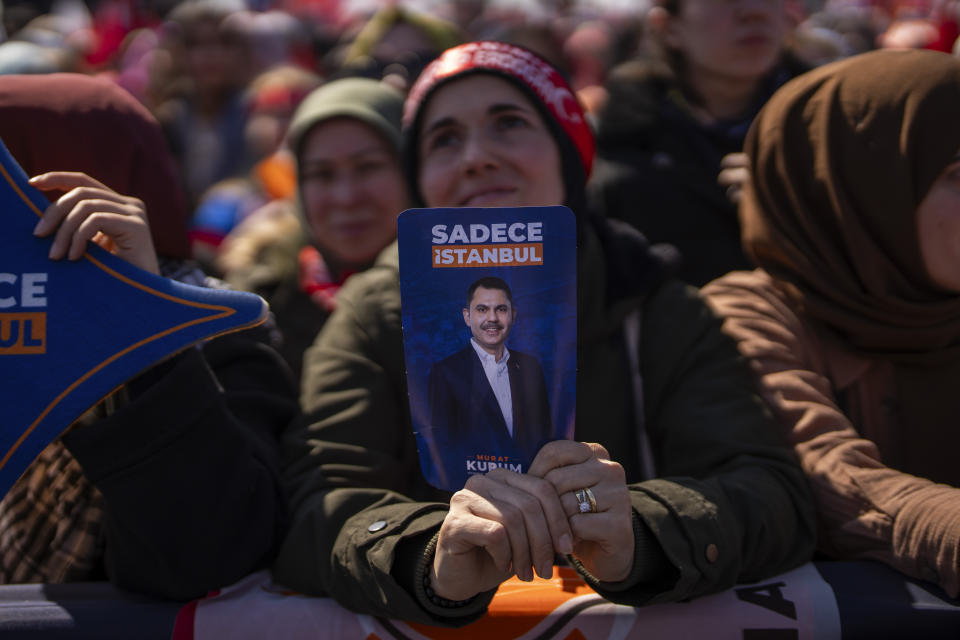 A supporters holds a flyer of Justice and Development Party, or AKP, candidate for Istanbul Murat Kurum during a campaign rally ahead of nationwide municipality elections, in Istanbul, Turkey, Sunday, March 24, 2024. On Sunday, millions of voters in Turkey head to the polls to elect mayors and administrators in local elections which will gauge President Recep Tayyip Erdogan’s popularity as his ruling party tries to win back key cities it lost five years ago. (AP Photo/Francisco Seco)