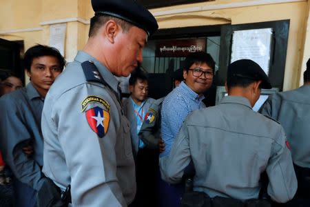 Detained Reuters journalists Wa Lone and Kyaw Soe Oo are being escorted by police after a court hearing in Yangon, Myanmar February 1, 2018. REUTERS/Jorge Silva/Files