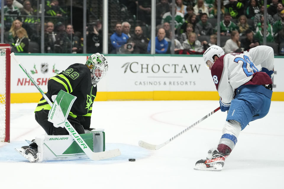 Colorado Avalanche left wing Miles Wood, right, skates with the puck before scoring a goal on Dallas Stars goaltender Jake Oettinger, left, during the second period of an NHL hockey game, Saturday, Nov. 18, 2023, in Dallas. (AP Photo/Julio Cortez)