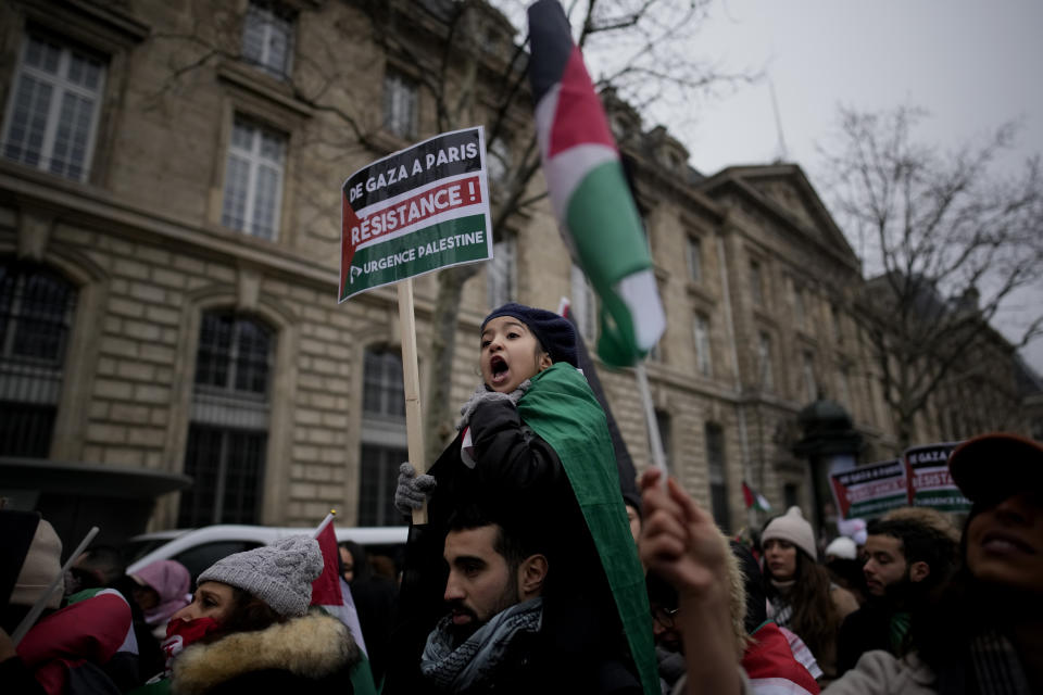 A young demonstrator holds a board reading "From Gaza to Paris. Resistance " during a pro-Palestinian rally in Paris, Saturday, Jan. 13, 2024. (AP Photo/Christophe Ena)