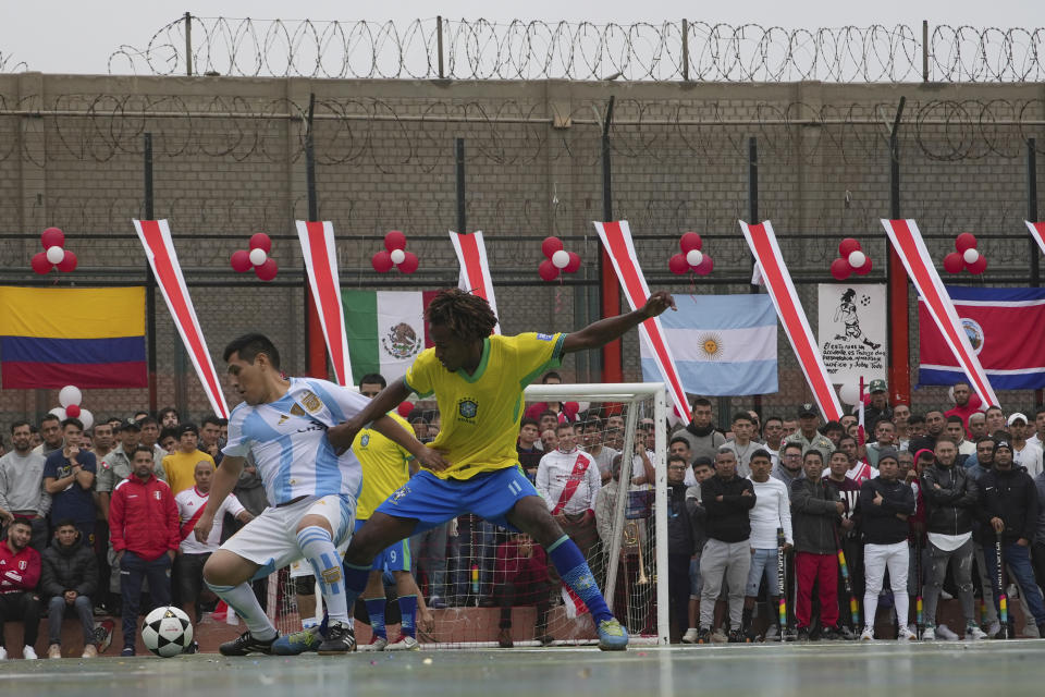 Presos pelean por el control de la pelota durante un partido de fútbol que es parte de la Copa América penitenciara en la prisión Sarita Colonia en Callao, Perú, el martes 18 de junio de 2024. (AP Foto/Guadalupe Pardo)