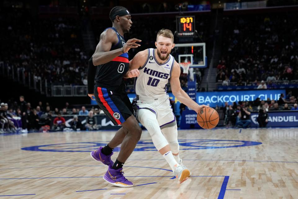 Kings forward Domantas Sabonis (10) drives on Pistons center Jalen Duren in the second half in Detroit, Friday, Dec. 16, 2022.